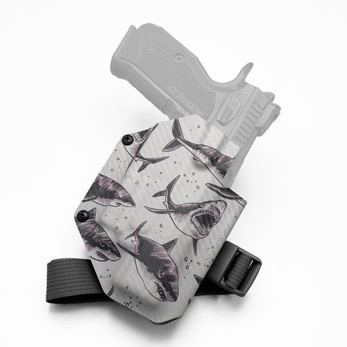 Tactical KYDEX range holster for CZ Shadow 2 equipped with Olight Baldr S, showing an aggressive great white shark print on carbon fiber texture and a 1" leg strap.
