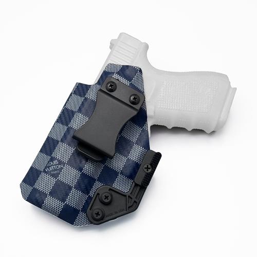 LV Damier on Carbon Fiber Pattern KYDEX left handed IWB holster holding a Glock 19, featuring a Quick Clip and Modwing Concealment Claw.